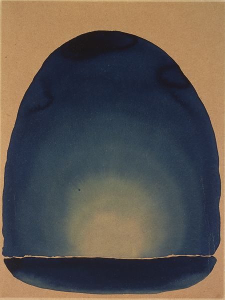 Watercolor. Arching washes of sky, royal, and navy blue blend to create a tall, egg-like shape on beige paper. A shallow, dish-like form of ultramarine blue runs across the bottom of the sheet. Above a narrow gap where the beige paper shows through, the tall form rises up into a dome. A pale glow at the bottom center of that form shifts to arctic blue and then deepens gradually to ultramarine around the top edge. Having worked wet-in-wet, the watercolor blends outward, like the rays of a rising sun. A few darker areas of blue are pooled around the top.